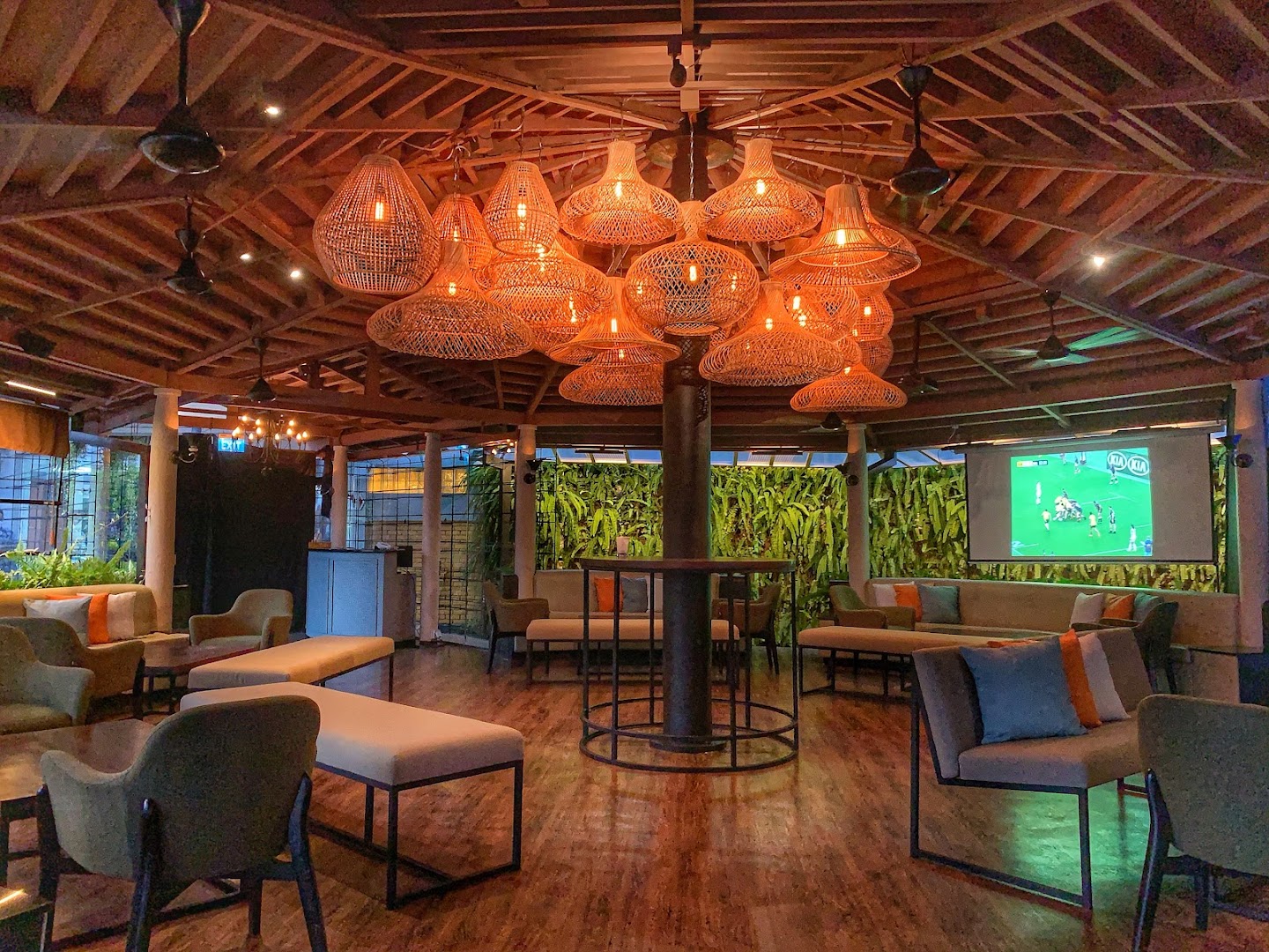 SunsetBlu interior with rattan globe pendant lights and tropical greenery feature wall