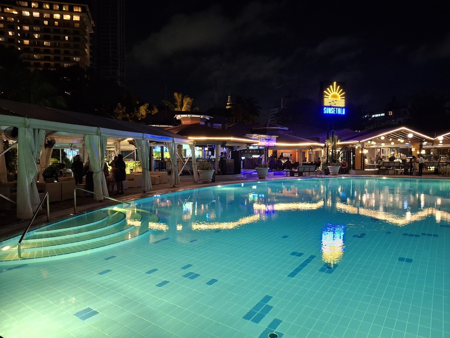 SunsetBlu neon sign illuminated at night above the poolside venue in Colombo