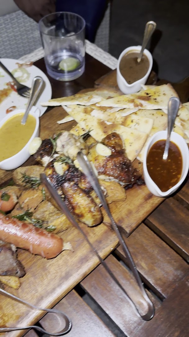 Mixed grill platter served on a rustic wooden board at SunsetBlu